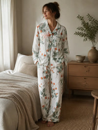 Femme portant le pyjama en gaze de coton motif rameaux de fruits rouges, chemise col claudine à liseré vert et pantalon large assorti