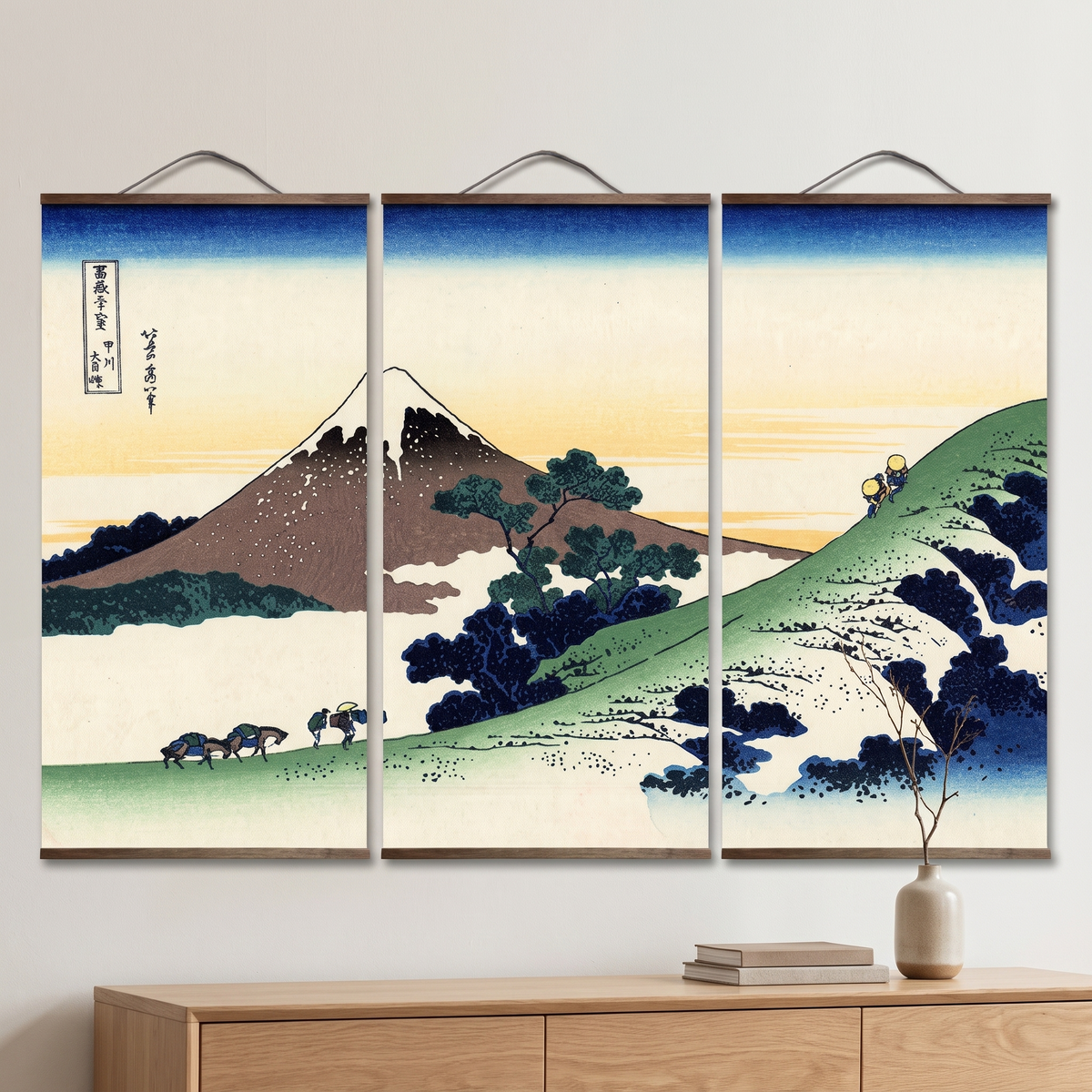 Triptyque estampe japonaise du mont Fuji, trois panneaux suspendus à tringles de bois, accroché au mur dans un intérieur clair