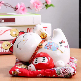 Meneki Neko couché avec Daruma